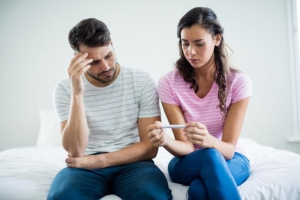 casal triste com teste negativo de gravidez