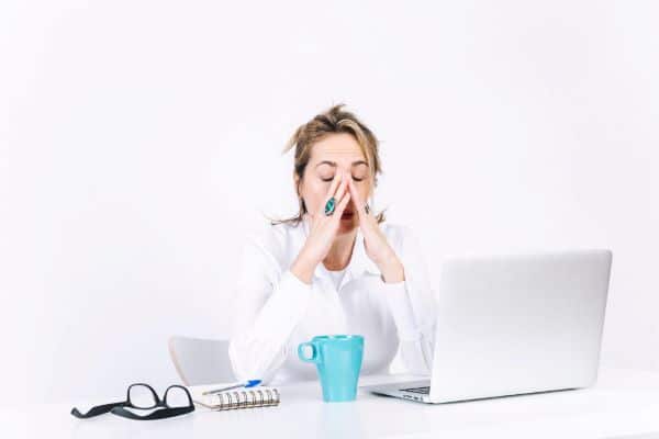 Estresse , cansaço de uma mulher frente ao laptop, tentando concluir as atividades de trabalho.